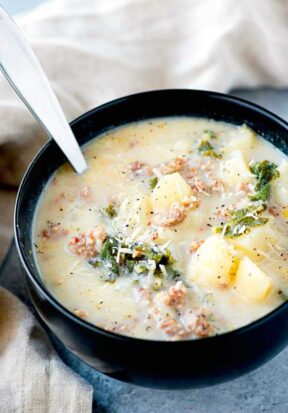 Side view of a large bowl filled with prepared zuppa toscana soup.