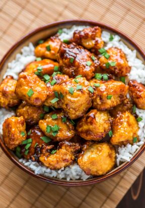 Easy baked sweet and sour chicken served on a bed of rice.