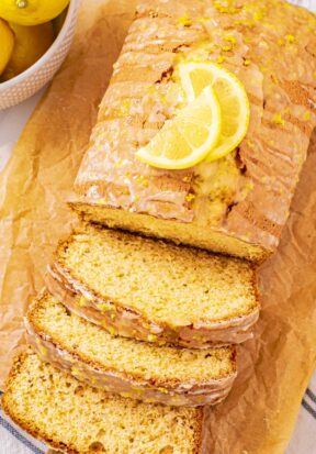 Top down view of lemon bread, with half of the loaf sliced and sliced pieces stacked to show texture inside the loaf.