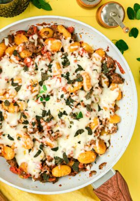 Top down view of a skillet full of freshly prepared gnocchi and sausage.