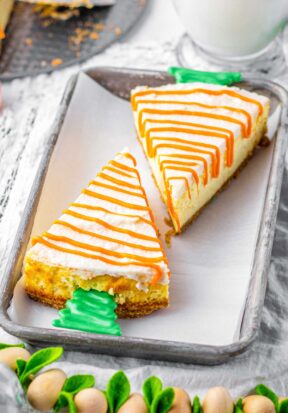 Slightly top down view of two pieces of cheesecake resting on a parchment lined baking sheet.